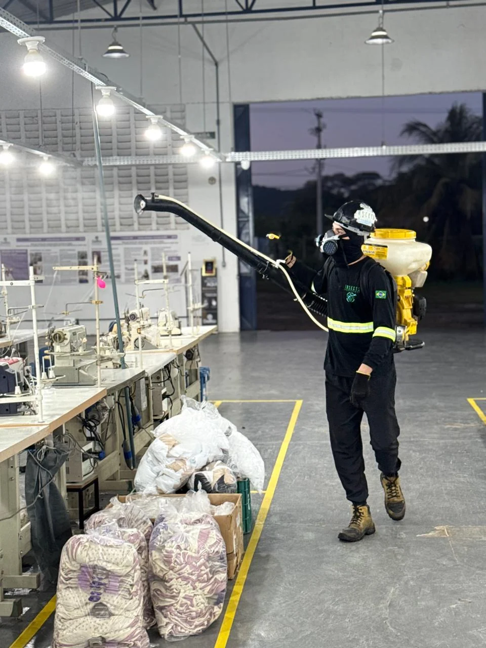 Técnico da Insects Dedetização realizando aplicação profissional em ambiente industrial